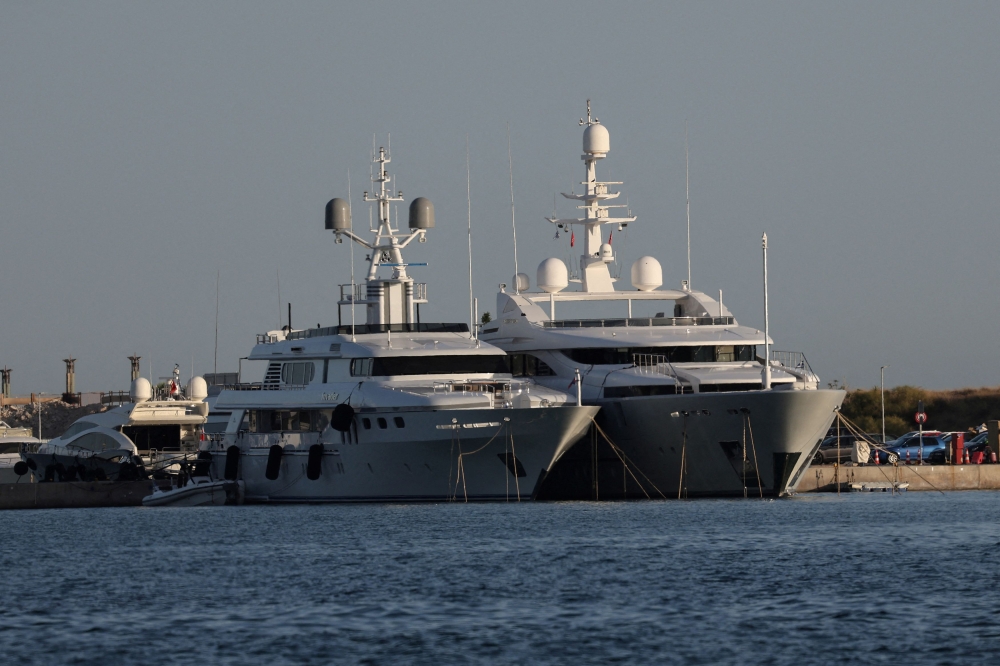 Greek prosecutors yesterday charged 13 crew members of a luxury yacht (right) accused of setting off fireworks that caused a major wildfire on an island near Athens, media reports said. — Reuters pic
