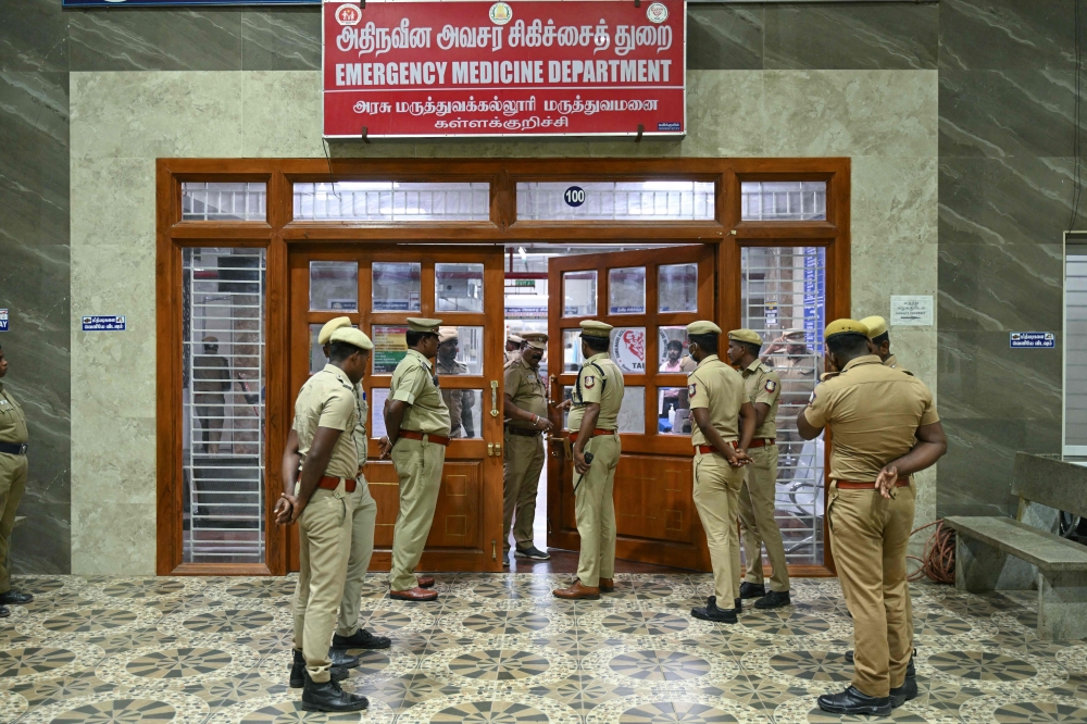 Police stand guard in front of a hospital ward where patients who consumed toxic illegal alcohol were admitted in Kallakurichi. — AFP pic