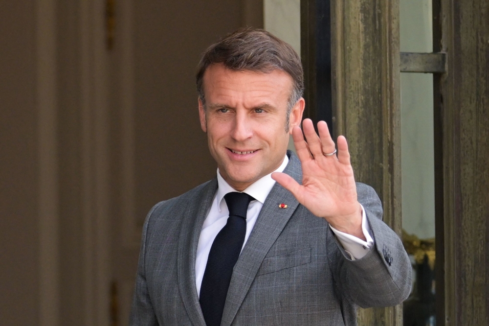 France's President Emmanuel Macron waves prior to a meeting with NATO'S Secretary General  at the Elysee Presidential Palace in Paris June 24, 2024. — AFP pic