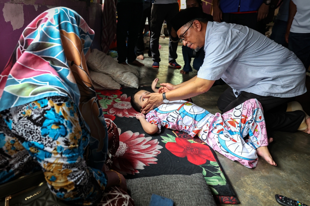 Pakatan Harapan (PH) candidate Joohari Ariffin visits disabled child Laila Lakisha Abdul Halim, nine years old, who suffers from hydrocephalus during his house-to-house campaign, June 25, 2024. — Bernama pic 