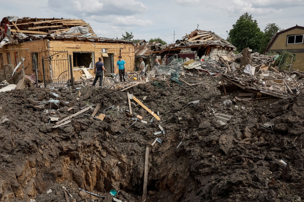 People stand near destroyed residential buildings at a site of a Russian missile strike, amid Russia's attack on Ukraine, in Pokrovsk, Donetsk region Ukraine June 24, 2024. — Reuters pic