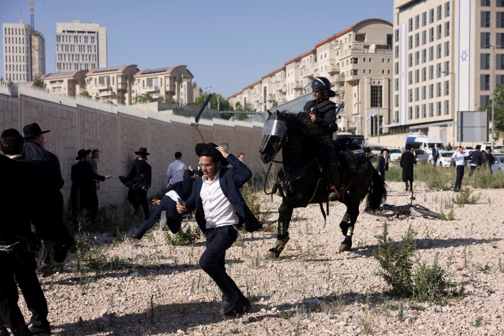 Security forces operate as Ultra-Orthodox Jewish men protest after Israel's Supreme Court convened to discuss petitions to change government policy that grants ultra-Orthodox Jews exemptions from military conscription, amid the ongoing conflict in Gaza between Israel and Palestinian Islamist group Hamas, near Israel's Supreme Court in Jerusalem, June 2, 2024. — Reuters pic