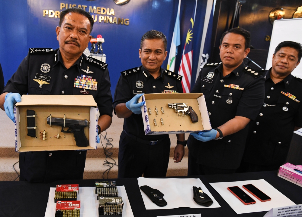 Penang police chief Datuk Hamzah Ahmad (left) shows two pistols and 176 rounds of ammunition seized at a press conference at the Penang State Police Contingent Headquarters (IPK) in George Town, June 26, 2024. The two pistols and bullets were confiscated from two criminals who were shot dead by the police earlier this morning at Jalan Permatang Baru, Sungai Lokan, Butterworth. — Bernama pic 