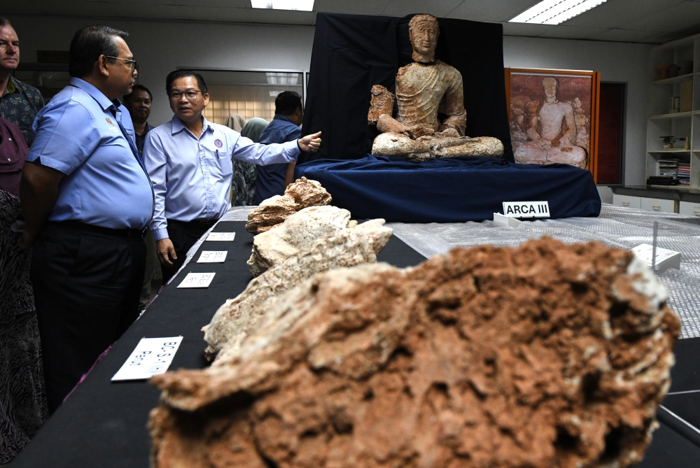 Tourism, Arts and Culture Ministry secretary-general Datuk Roslan Abdul Rahman (left) briefed by the director of the Global Archaeological Research Centre (PPAG) of Universiti Sains Malaysia, Prof Stephen Chia Ming Soon at the centre in George Town, June 26, 2024. — Bernama pic 
