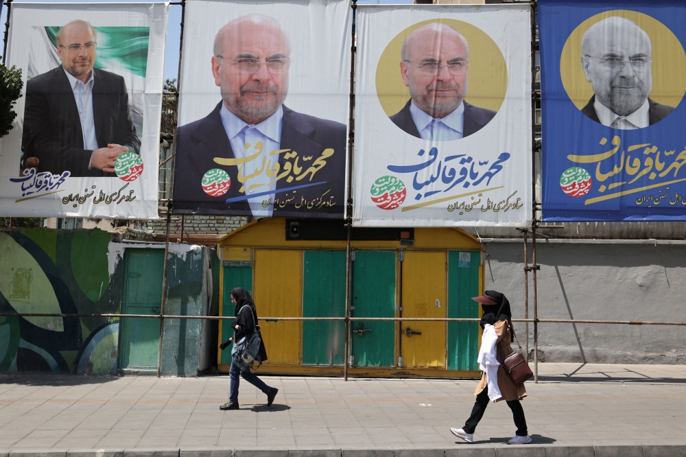 People walk past banners of presidential candidate Mohammad Bagher Ghalibaf displayed on a street in Tehran, Iran June 27, 2024. — Picture by West Asia News Agency via Reuters