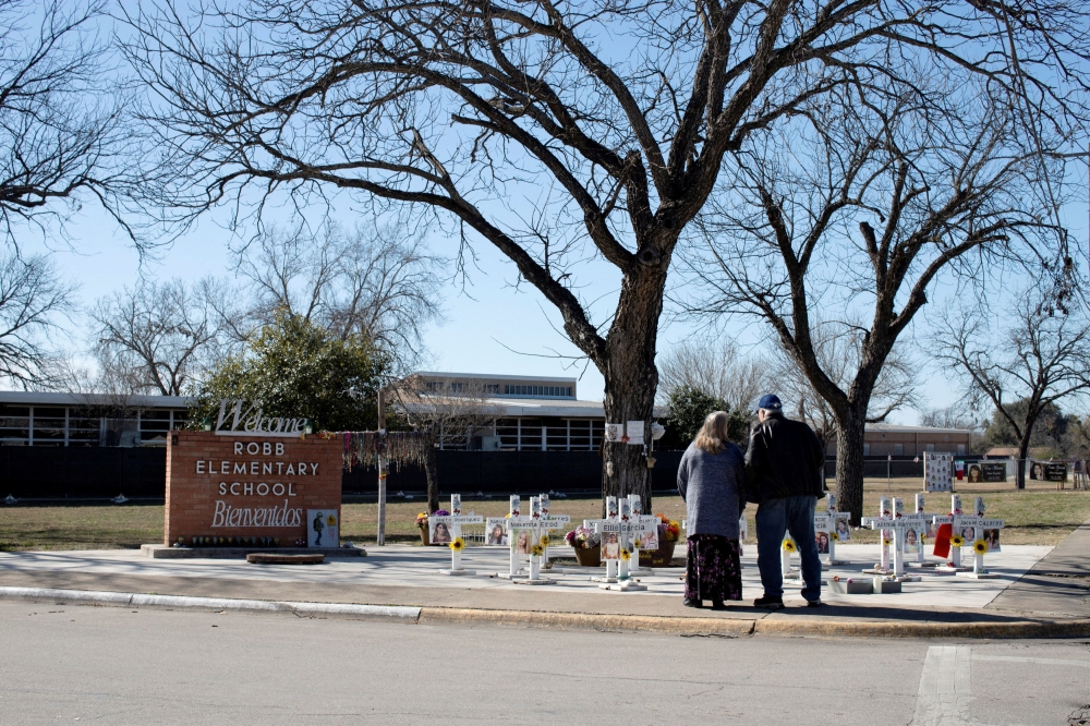 A couple visits memorial crosses in front of Robb Elementary School, as US Attorney General Merrick Garland announces the results of a review into the law enforcement response to a 2022 mass shooting in Uvalde, Texas, US, January 18, 2024. — Reuters pic