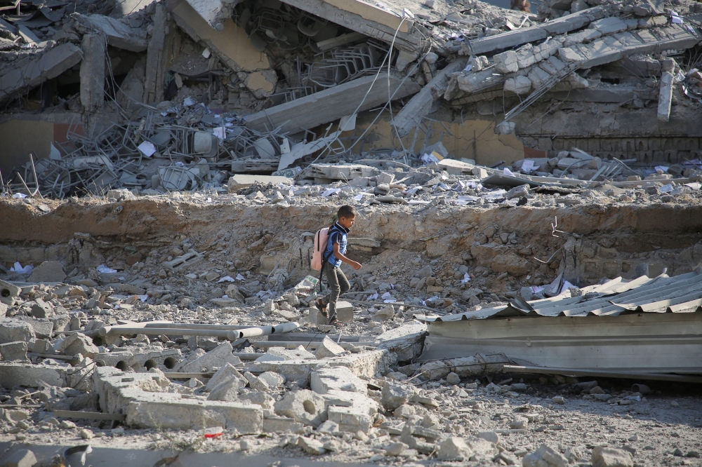 A Palestinian boy walks on rubble, following an Israeli strike on a school sheltering displaced people, amid the Israel-Hamas conflict, in Khan Younis, in the southern Gaza Strip, June 27, 2024. — Reuters pic