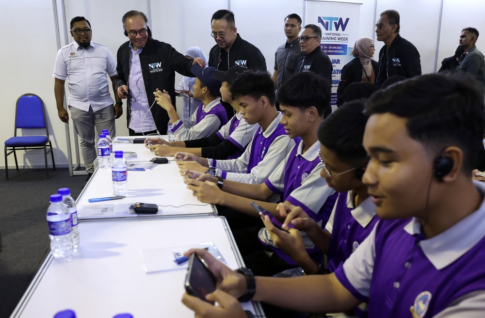 Prime Minister Datuk Seri Anwar Ibrahim and Human Resources Minister Steven Sim Chee Keong reviewe the activities held in conjunction with the National Training Week 2024 at the Bukit Jalil National Stadium June 30, 2024. — Bernama pic
