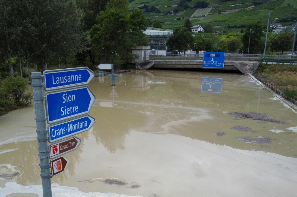 An aerial picture taken on June 30, 2024 shows a road flooded near Sierre, western Switzerland. Ferocious storms and torrential rains that lashed France, Switzerland and Italy this weekend have left five people dead, local authorities said today. — AFP pic