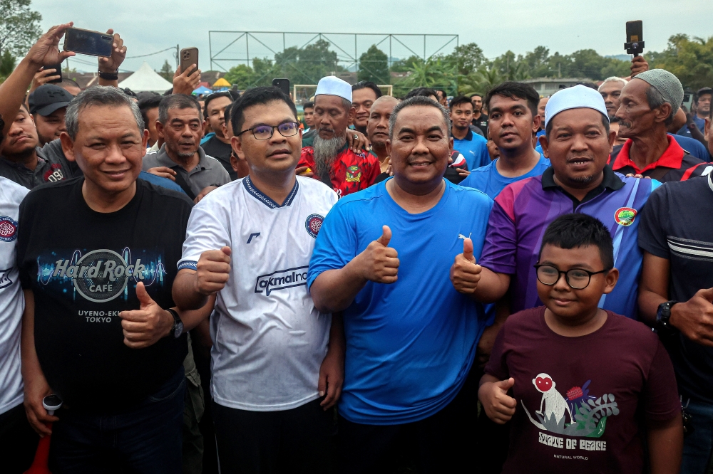 Kedah Menteri Besar Datuk Seri Muhammad Sanusi Md Nor poses with Deputy Minister of Energy Transition and Water Transformation Akmal Nasrullah Mohd Nasir (2nd left) at a friendly football match between Akmal Nasrullah’s team and Muhammad Sanusi’s team at Taman Pekatra Ampat junction in Nibong Tebal June 30, 2024. — Bernama pic