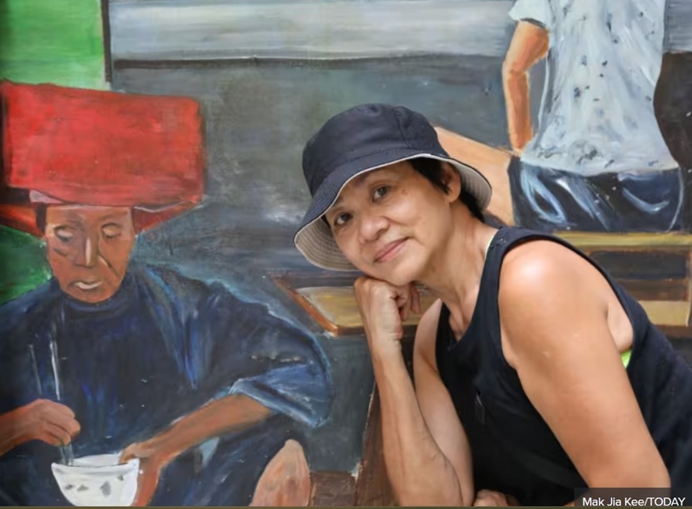 Mural artist Belinda Low posing with one of her artworks in Chinatown in Singapore June 26, 2024. — TODAY pic