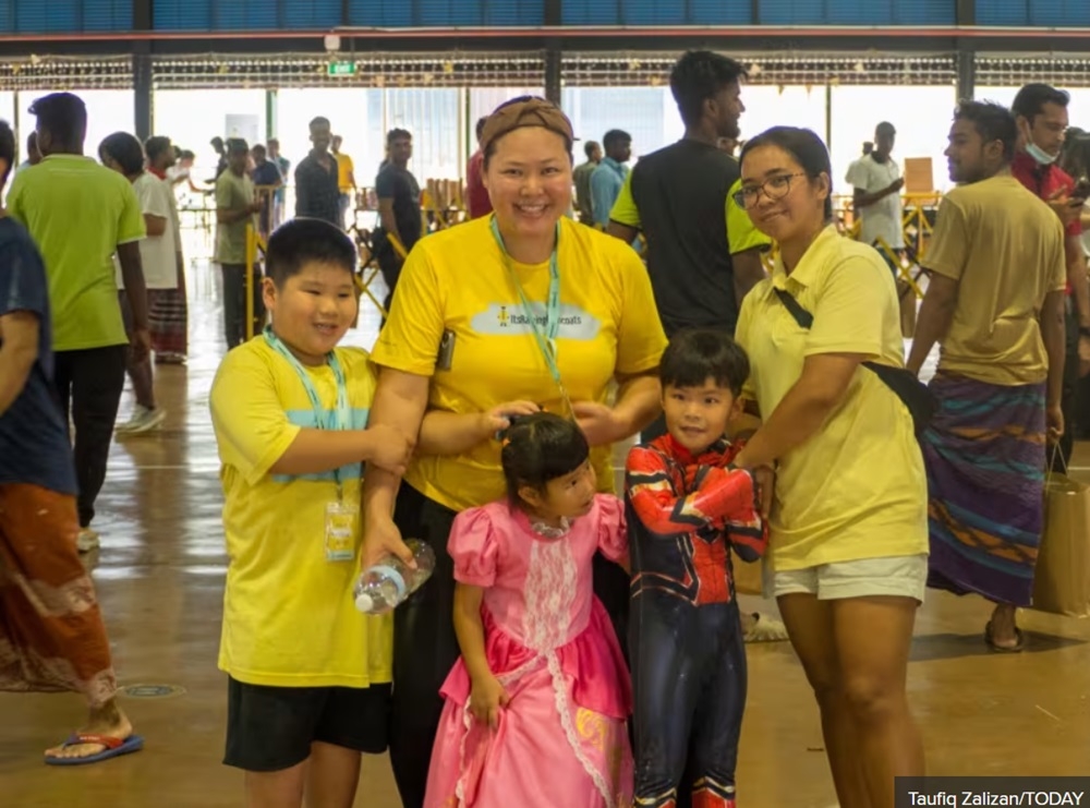 Regular volunteer Shallene Lim (centre), her three children and helper (right) at a migrant worker event organised by Its Raining Raincoats in Singapore June 23, 2024. — TODAY pic 