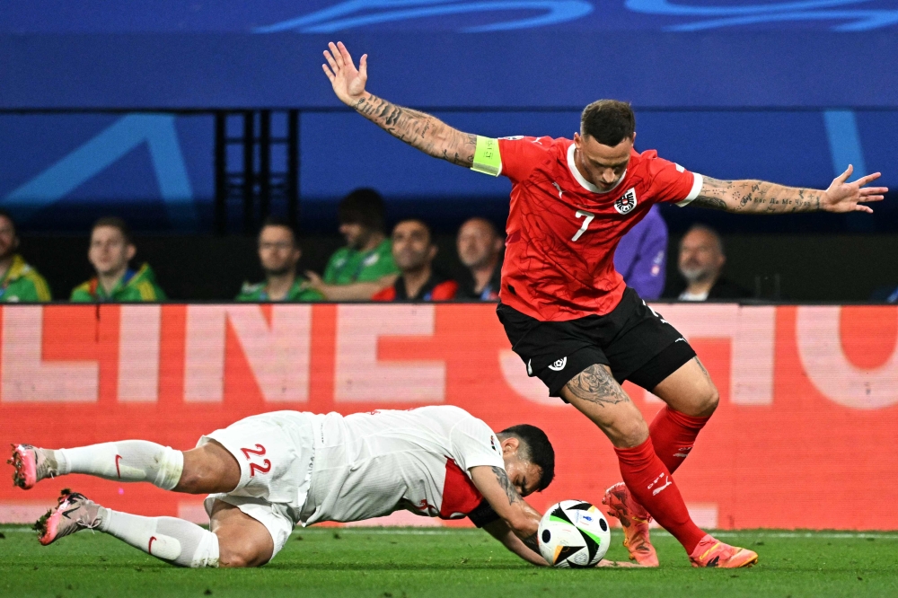 Austria’s forward #07 Marko Arnautovic fights for the ball with Turkey’s midfielder #22 Kaan Ayhan. — AFP pic