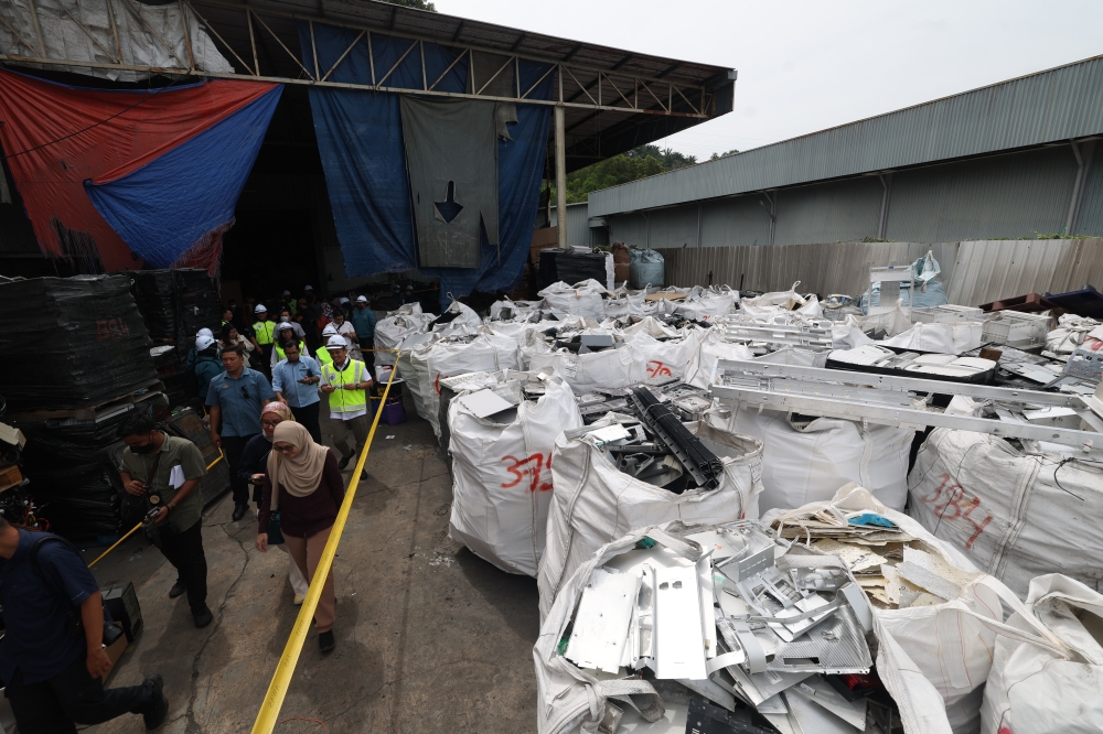 Minister of Natural Resources and Environmental Sustainability Nik Nazmi Nik Ahmad observes various recycled plastic items while participating in Operation Patuh involving two factories in Kuala Muda July 3, 2024. — Bernama pic