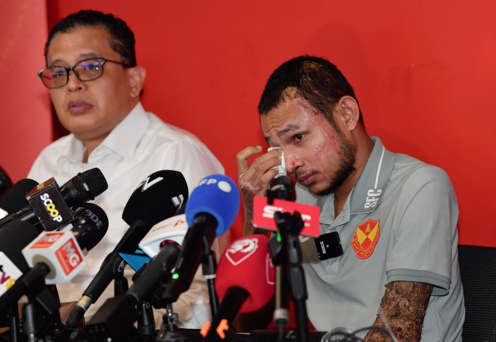 National footballer Mohamad Faisal Abdul Halim (right) reacts during a press conference in Shah Alam June 13, 2024. — Bernama pic