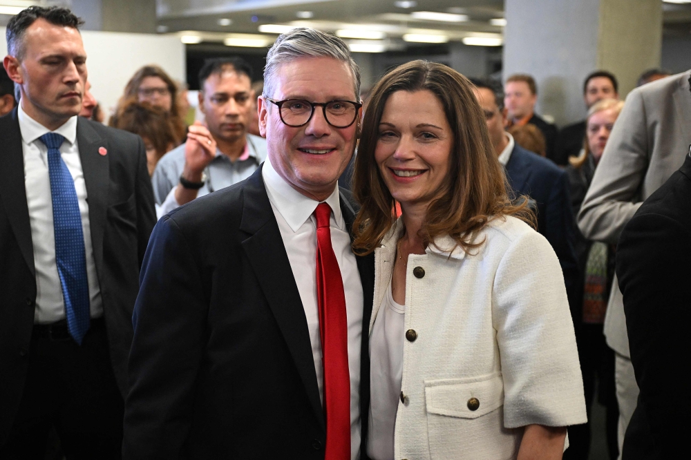 Britain’s Labour Party leader Keir Starmer poses with his wife Victoria before results are declared at the Camden Council count centre in London early on July 5, 2024. — AFP pic