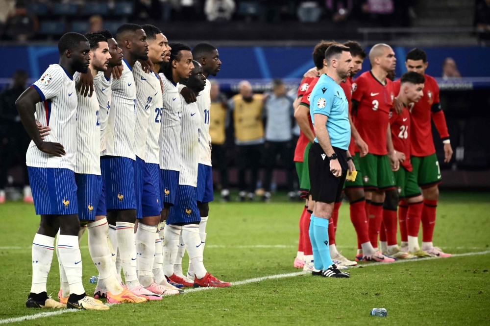 France’s and Portugal’s players line up during a penalty shoot-out. — AFP pic