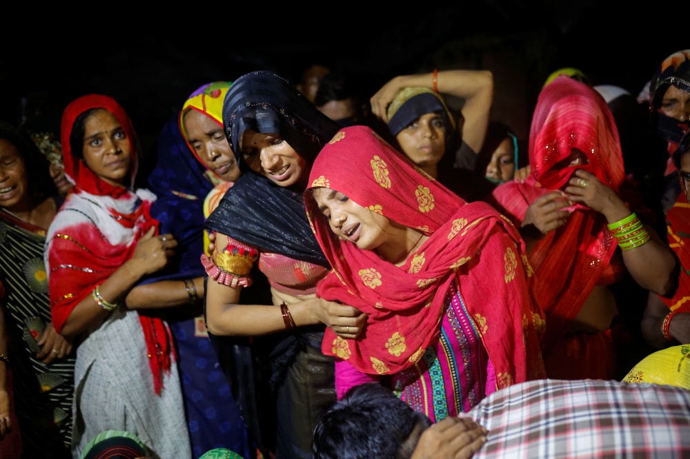 Relatives mourning the death of stampede victims. The chief organiser of an Indian preacher’s event where a stampede killed 121 people this week surrendered to police today, a lawyer for the preacher said, after police had launched a manhunt. — Reuters pic