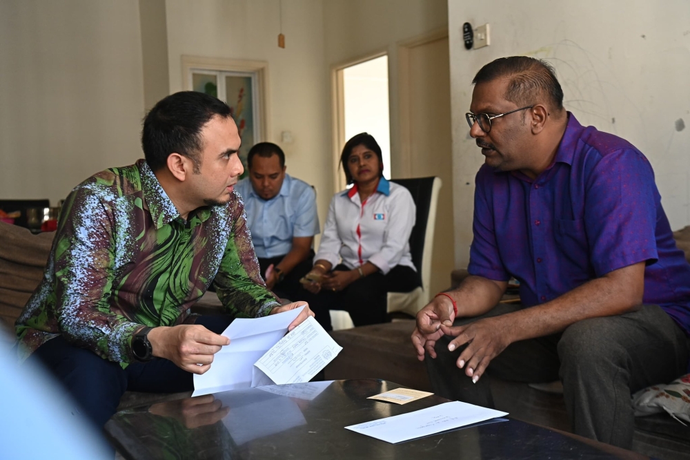 The prime minster’s political secretary, Ahmad Farhan Fauzi, speaks with reformist Henry Albert (front, right) in this undated photograph. — Picture from X/@anwaribrahim