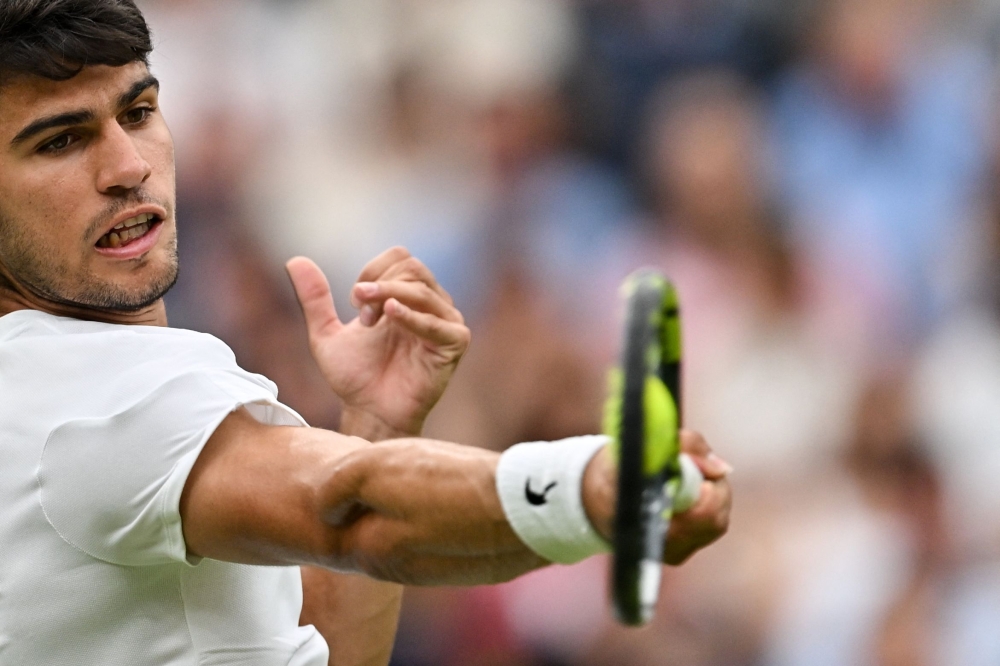 Defending champion Carlos Alcaraz defeated close friend Frances Tiafoe in a roller-coaster five sets to reach the Wimbledon last 16 yesterday. — AFP pic