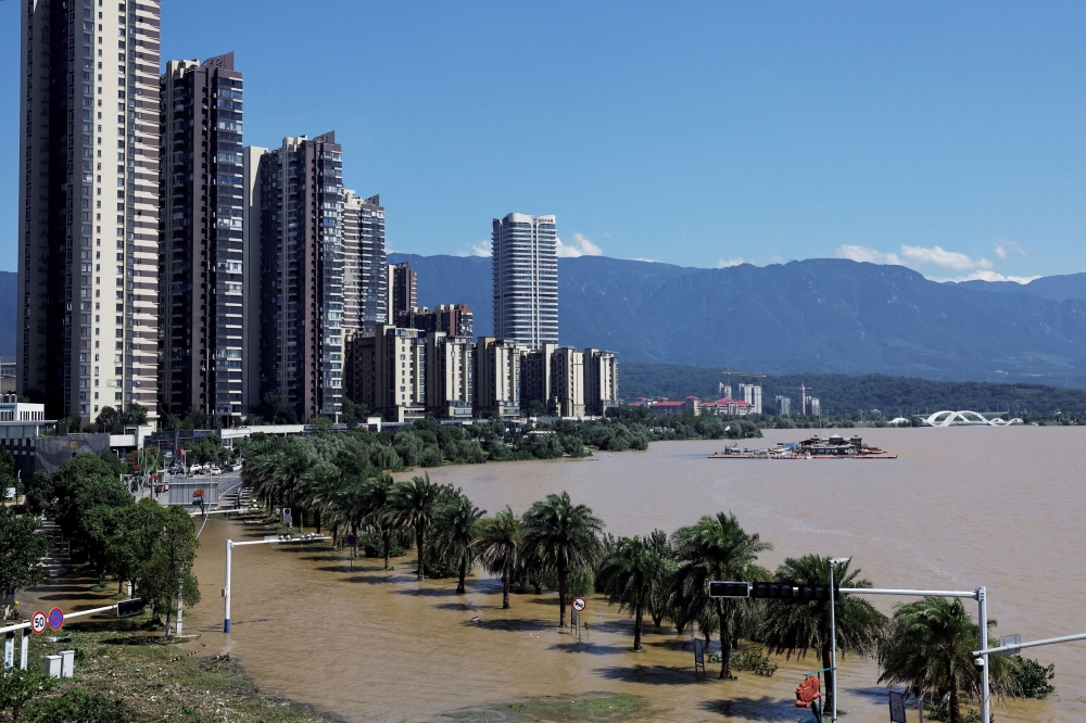 A flooded road is seen by a swollen lake following heavy rainfall in the region, in Jiujiang, Jiangxi province, China July 4, 2024. — Reuters pic