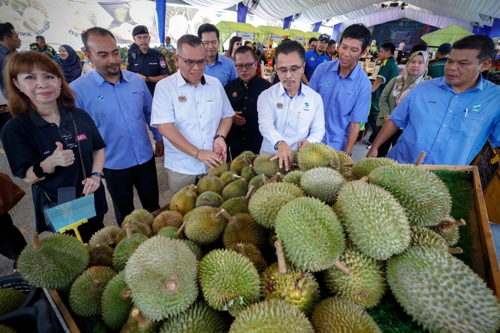 Federal Agricultural Marketing Authority director-general Abdul Rashid Bahri (centre) inspects durians after officiating the ‘Program Kendurian@Jualan Agro Madani’ at a supermarket in Melaka July 6, 2024. — Bernama pic