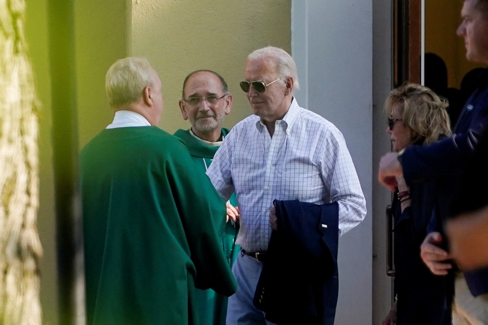 Biden greets a priest as he departs outside St. Joseph on the Brandywine Roman Catholic Church in Wilmington, Delaware. — Reuters pic