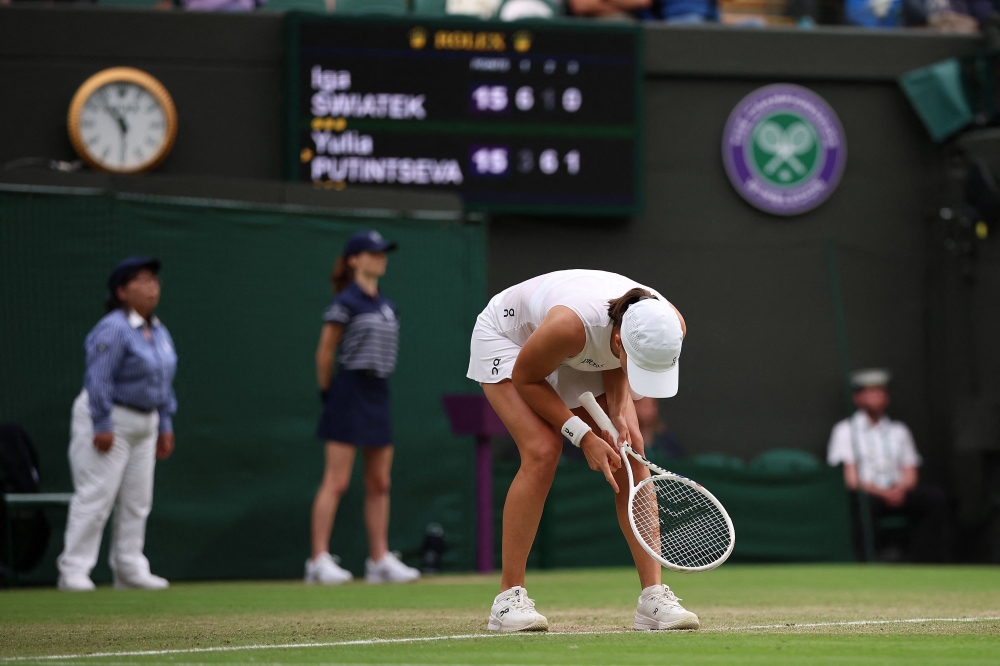 Poland's Iga Swiatek reacts after losing a point in the third set against Kazakhstan's Yulia Putintseva during their women's singles tennis match on the sixth day of the 2024 Wimbledon Championships at The All England Lawn Tennis and Croquet Club in Wimbledon July 6, 2024. — AFP pic