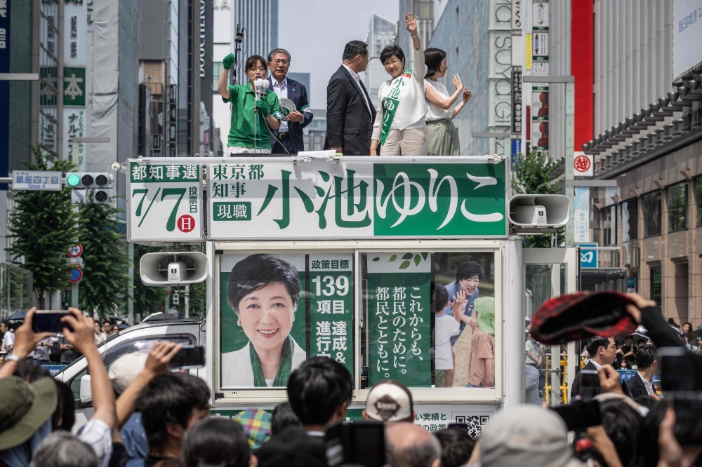 Tokyo gubernatorial election candidate and Governor of Tokyo Yuriko Koike (second from right) waves during an election campaign in Tokyo on July 6, 2024. — AFP pic