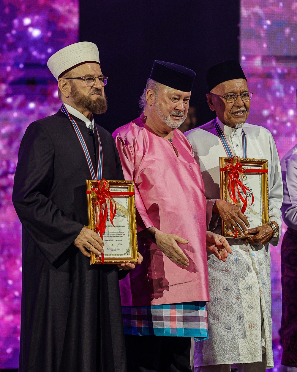 His Majesty Sultan Ibrahim is pictured with Prof Ali Muhyiddin Ali Al-Qaradaghi (left) and Datuk Seri Hassan Ahmad (right) during national-level Maal Hijrah 1446H/2024M celebrations in Putrajaya July 7, 2024. — Bernama pic