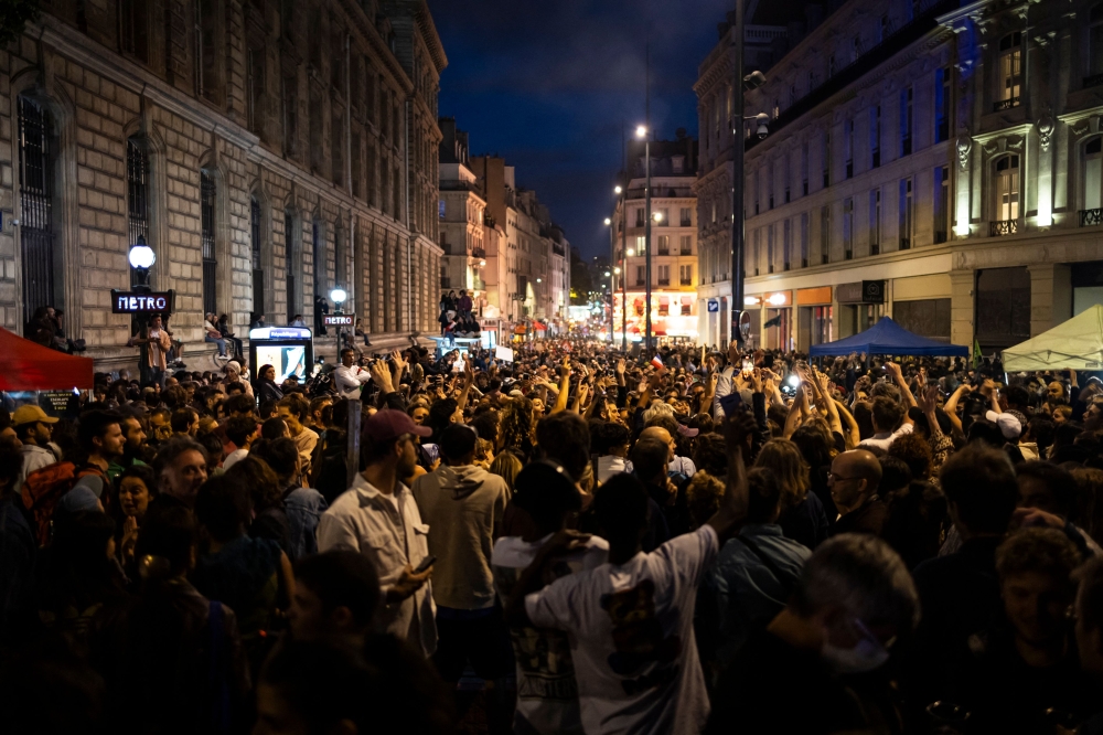 People celebrate during an election night rally following the first results of the second round of France's legislative election at Republique Square in Paris on July 7, 2024. — AFP pic
