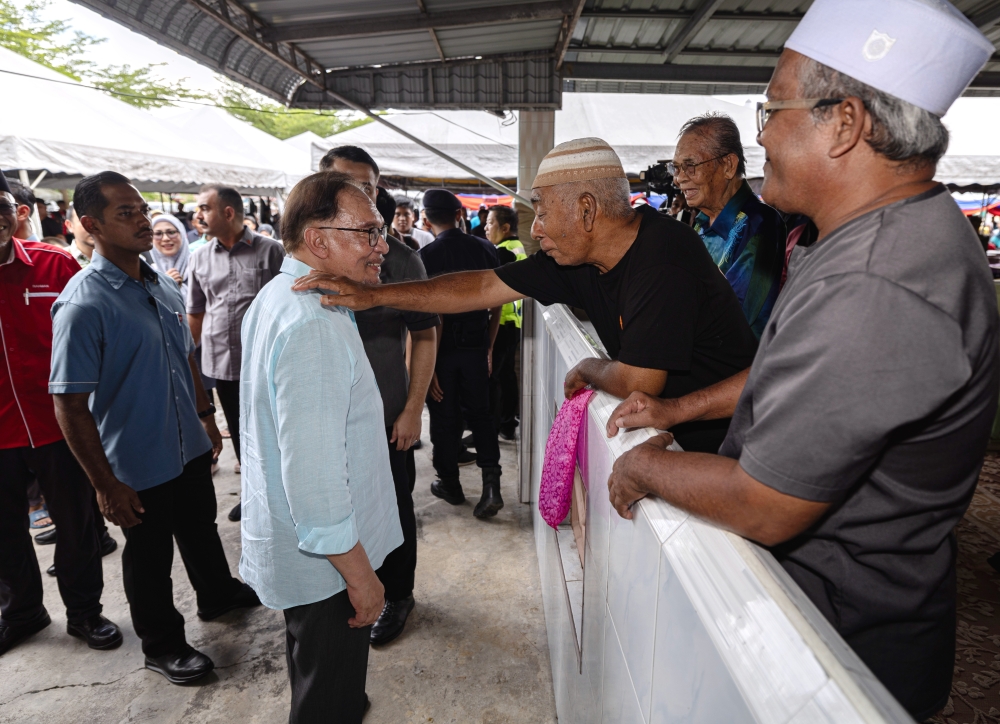 Prime Minister Datuk Seri Anwar Ibrahim with the public during the Mega Bubur Asyura Stirring Programme for the Tambun parliamentary constituency in conjunction with the 1446 H Muharram Celebration at the As-Saadah Manjoi Mosque compound, Ipoh, July 8, 2024. — Bernama pic 