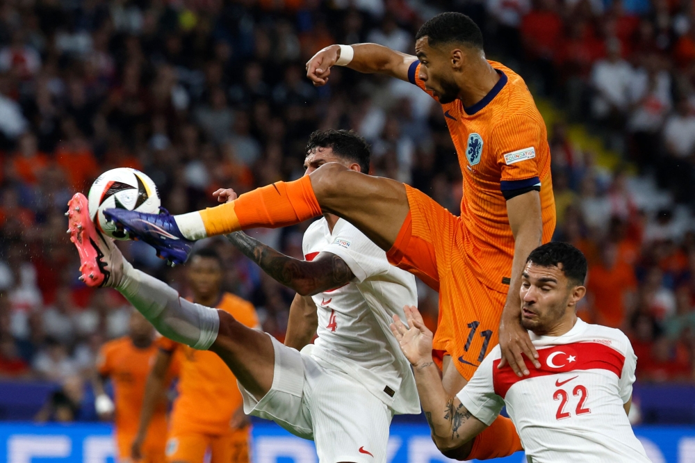 (From left) Turkey’s defender Samet Akaydin and Turkey’s midfielder Kaan Ayhan and Netherlands’ forward Cody Gakpo fight for the ball during the Uefa Euro 2024 quarter-final match between the Netherlands and Turkey at the Olympiastadion in Berlin on July 6, 2024. — AFP pic 
