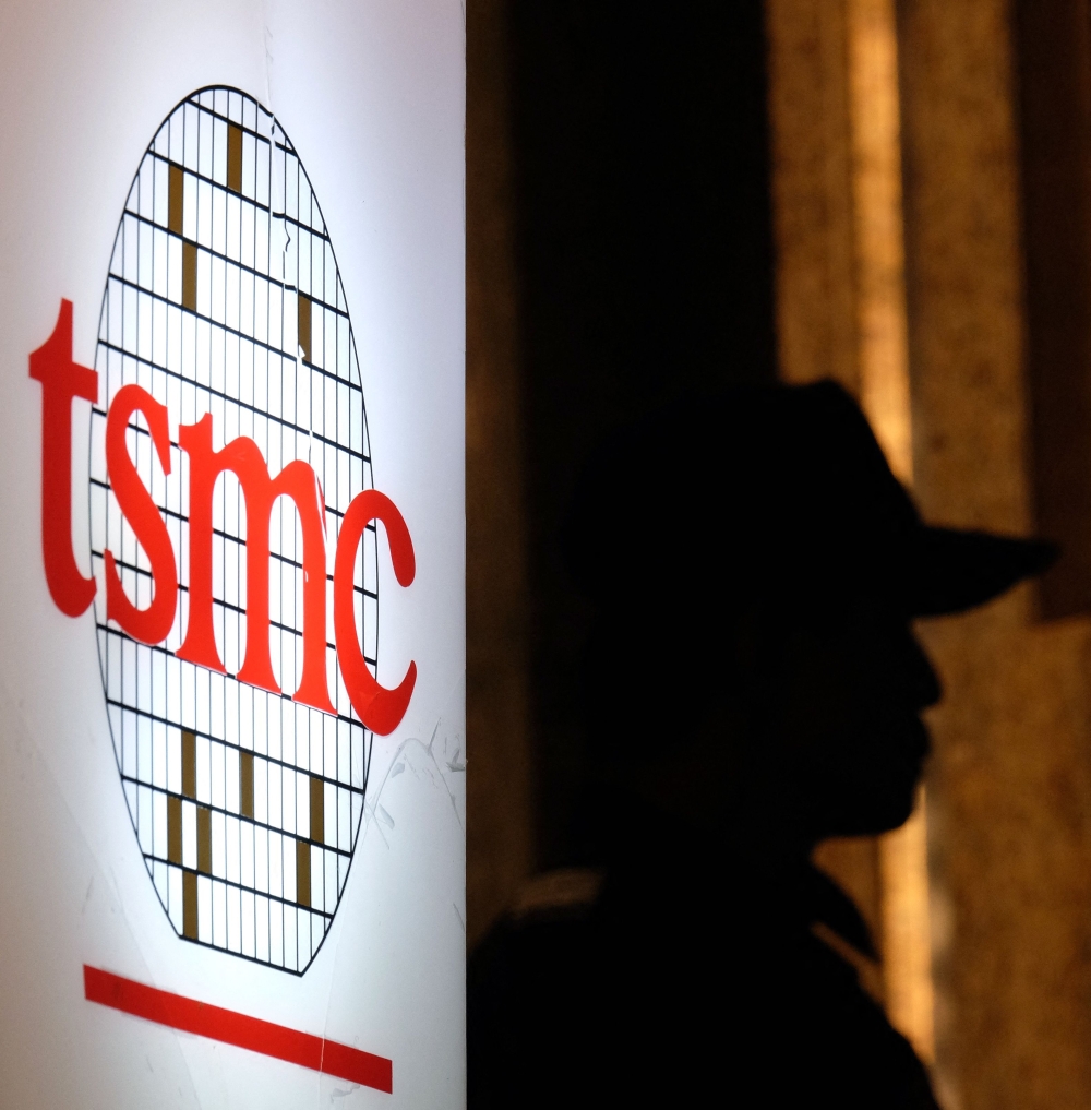 File picture of a security staff standing next to a logo of the Taiwan Semiconductor Manufacturing Co, (TSMC), during the investors conference in Taipei on July 16, 2014. TSMC, listed in both Taiwan and New York, briefly broke the one trillion dollar market capitalisation barrier on Monday, putting it ahead of Tesla as the seventh most valuable technology giant on the stock market. — AFP pic 