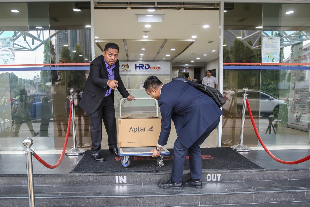 ​​MACC officers seen carting out boxes of files from the HRD Corp office in Damansara Heights, Kuala Lumpur July 9, 2024. — Picture by Yusof Mat Isa