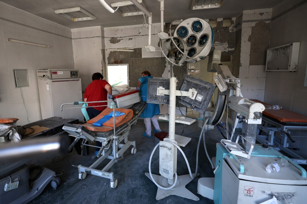 Medical personnel evacuate the surviving equipment in the operating room of the destroyed building of Ohmatdyt Children's Hospital, a day after a missile attack in Kyiv on July 9, 2024, amid the Russian invasion in Ukraine. Targeting hospitals in Ukraine is a 