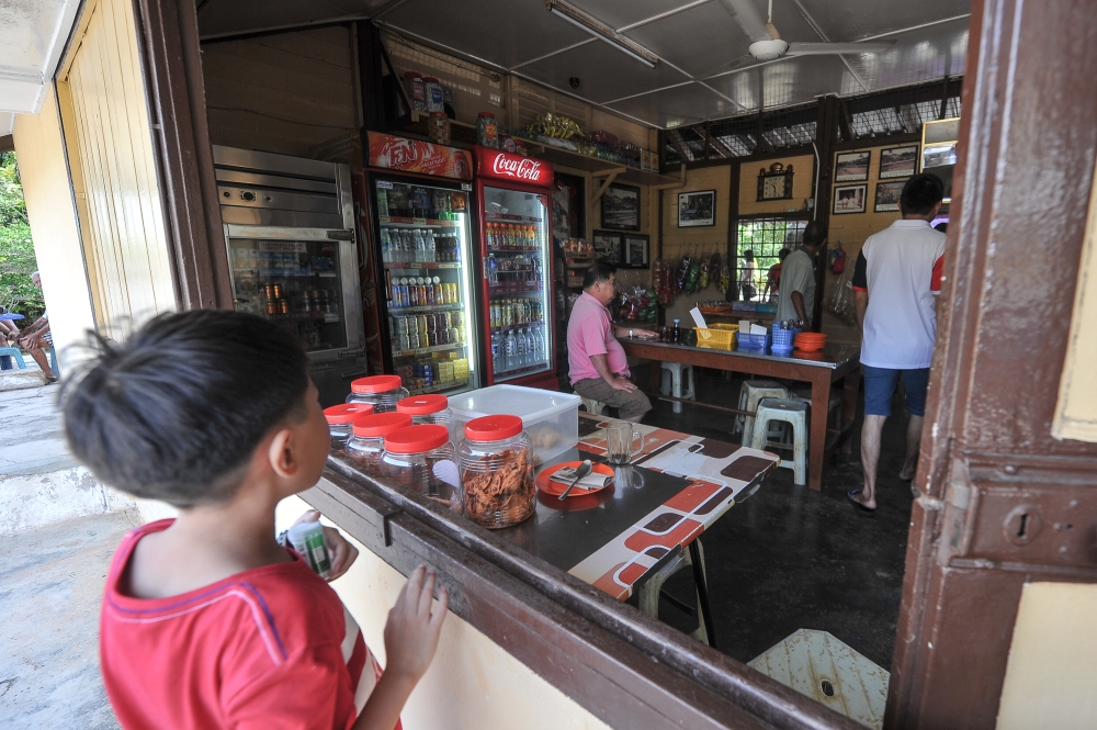 This 2018 file photograph shows a child waiting to order at a railway station canteen in Pekan Paloh, Johor.  — Picture by Shafwan Zaidon
