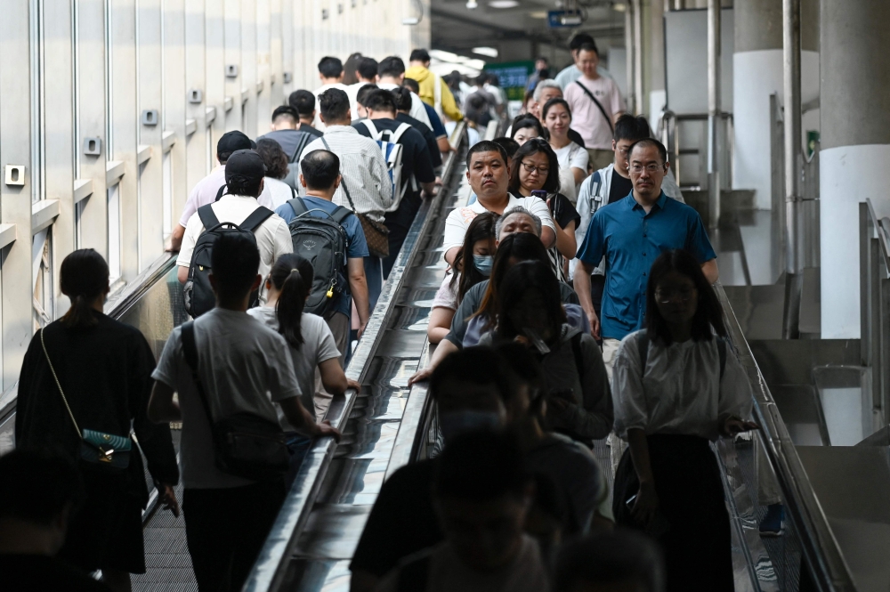 Commuters take the escalators at a subway station in Beijing on July 10, 2024. The world’s second-largest economy is grappling with a real estate debt crisis, weakening consumption, an ageing population and geopolitical tensions overseas. — AFP pic 