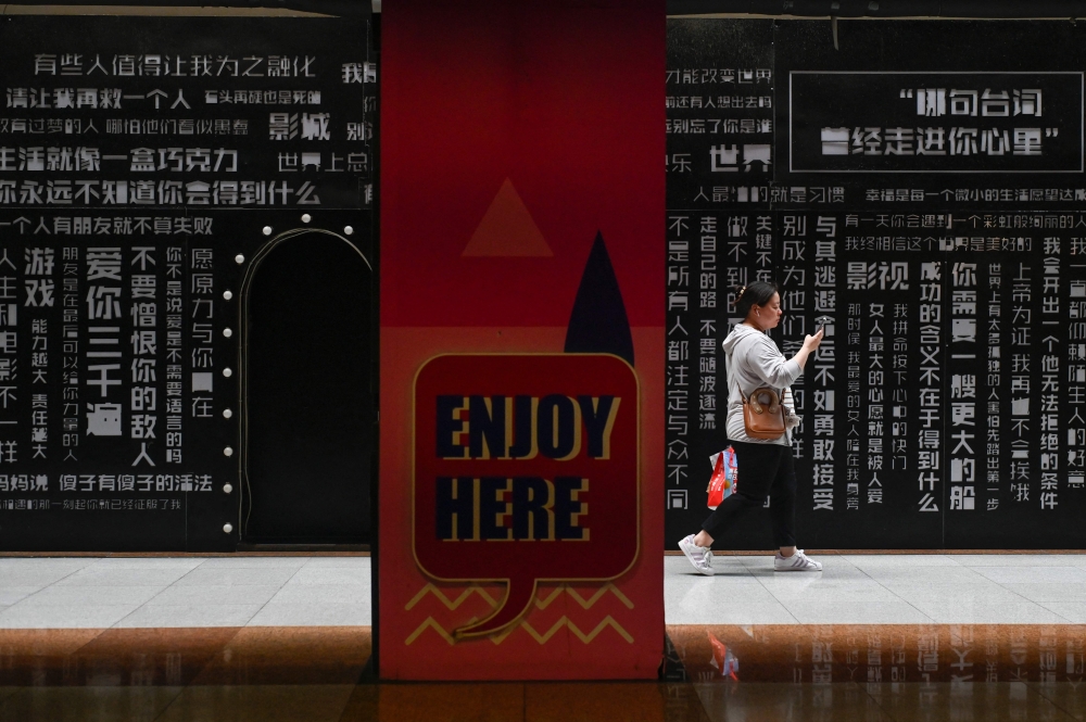 A woman walks at a mall in Beijing on July 10, 2024. Asian stocks on Thursday tagged along with a Wall Street rally that saw another round of record highs as bets on a September interest rate hike surged following comments by Federal Reserve boss Jerome Powell. — AFP pic 
