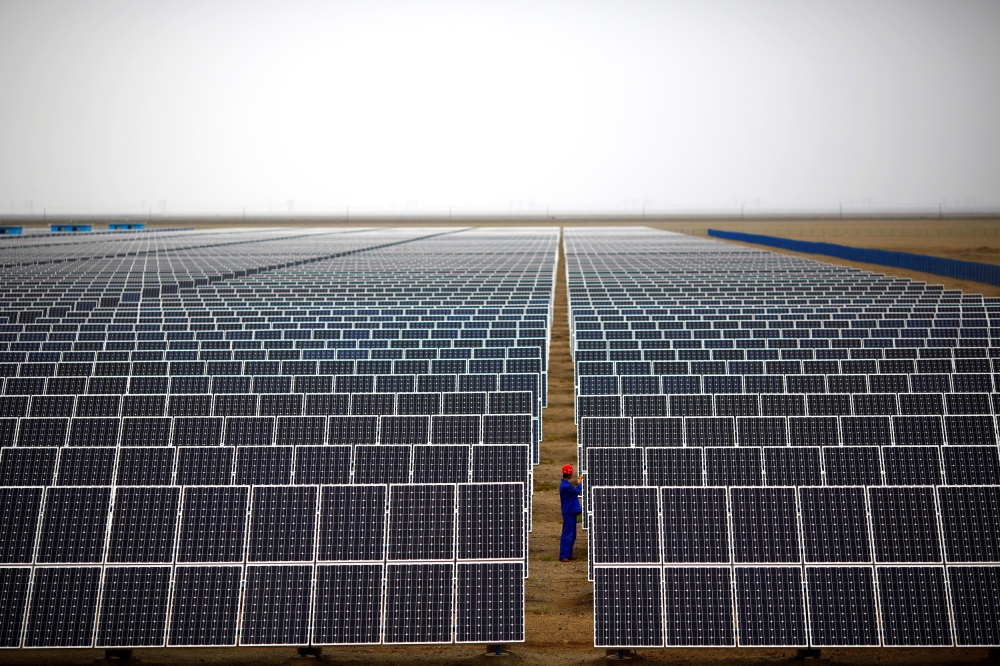 A worker inspects solar panels at a solar farm in Dunhuang, 950km north-west of Lanzhou, Gansu Province in this file picture dated September 16, 2013. — Reuters pic 