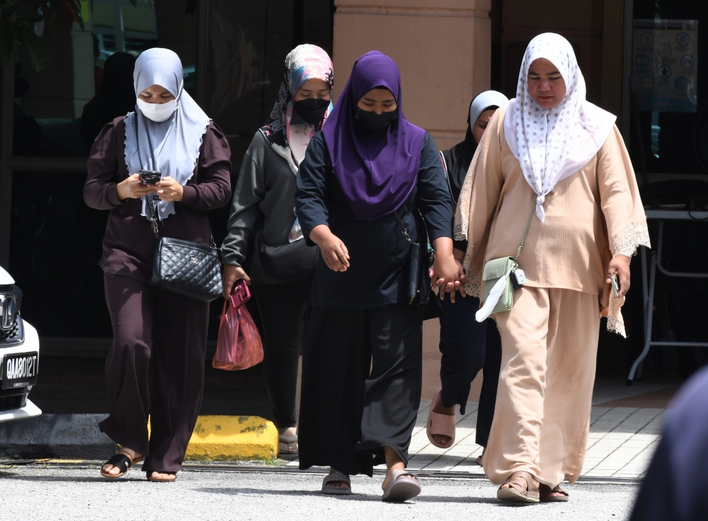 Nurain Hasnorizal, 25, (3rd left) mother of the three-year-old boy Muhammad Akil Syauqi Nur Sufian, who died today after consuming crackers believed to contain rat poison, exits the Forensic Medicine Department at Penang Hospital after viewing her son’s body, July 10, 2024. — Bernama pic 