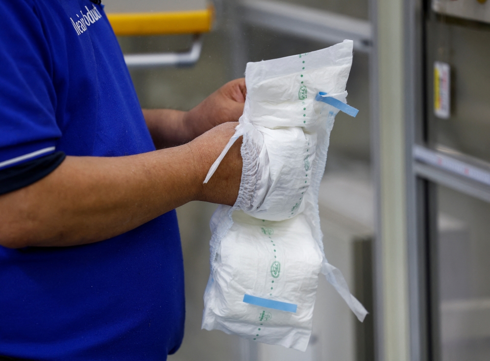 An employee works on an adult diaper production line at a factory of Daio Paper Corporation's subsidiary Elleair in Fujinomiya, Shizuoka prefecture, Japan June 18, 2024. — Reuters pic