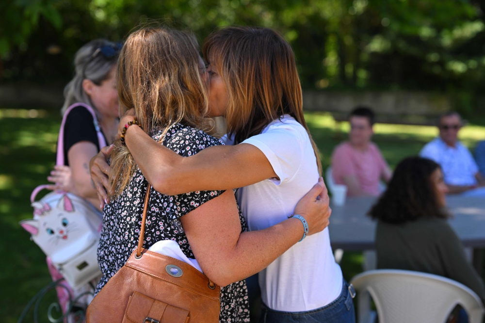 Mothers of children who committed suicide hug during a meeting of Le Point Rose, an association helping parents of deceased children which organises 'family days', in Cabries, southern France, on June 2, 2024. — AFP pic