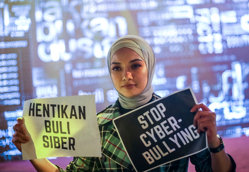 Malaysian celebrity Noor Neelofa Mohd Noor holds up anti-cyberbullying posters in English and Malay during an awareness campaign in Kuala Lumpur. — Picture by FIrdaus Latif