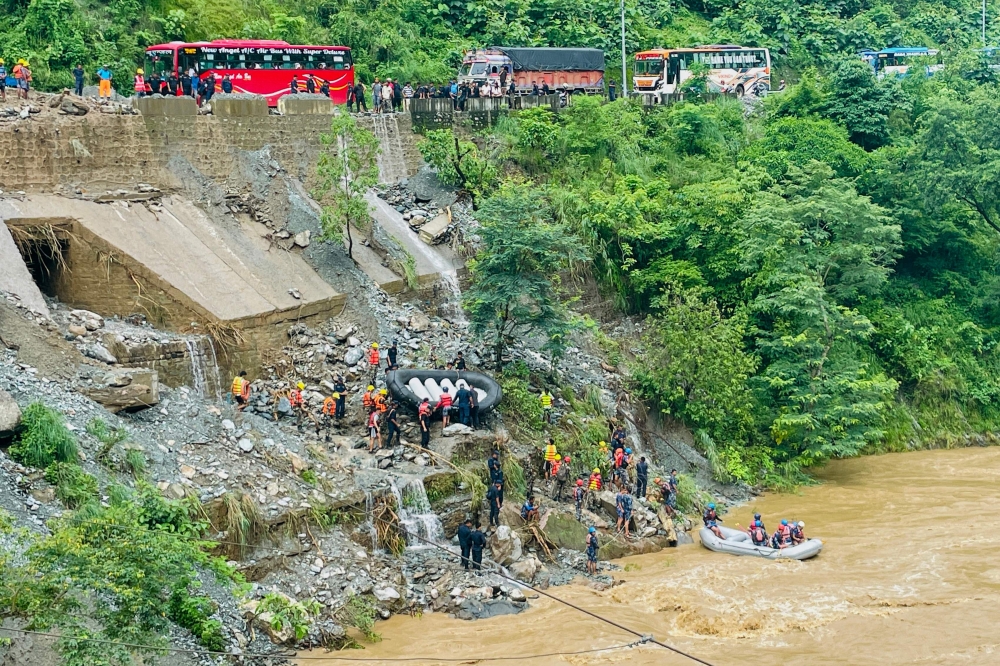 Nepali rescue teams resumed their search early today for at least 63 people missing after monsoon rains triggered a landslide that swept two buses off a highway and into a river. — AFP pic