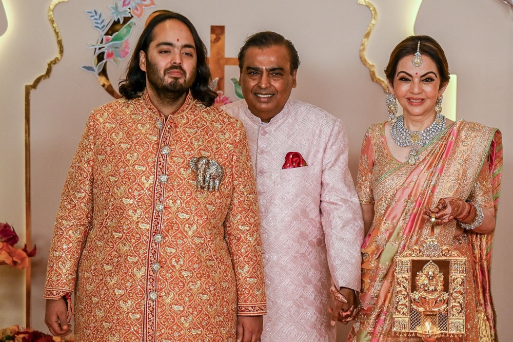 Billionaire tycoon and chairman of Reliance Industries Mukesh Ambani (centre), wife Nita Ambani (right) and son Anant Ambani at the wedding ceremony in Mumbai. — AFP pic