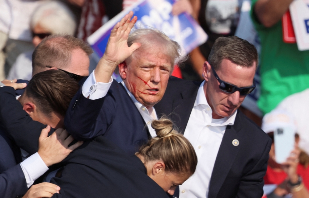 Republican presidential candidate and former US President Donald Trump is assisted by US Secret Service personnel after gunfire rang out during a campaign rally at the Butler Farm Show in Butler, Pennsylvania, July 13, 2024. — Reuters pic