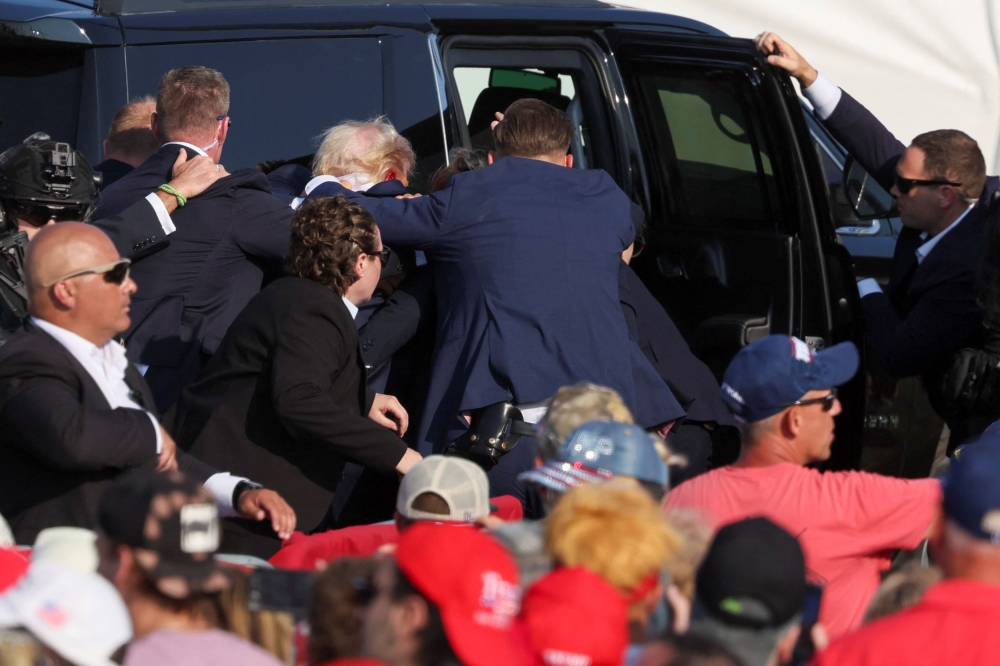 Republican presidential candidate and former US President Donald Trump gets into a vehicle with the assistance of US Secret Service personnel after he was shot in the right ear during a campaign rally at the Butler Farm Show in Butler, Pennsylvania, July 13, 2024.  — Reuters pic 