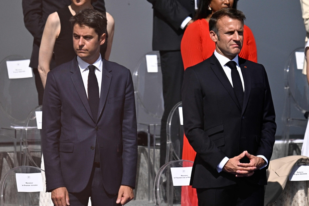 Prime Minister Gabriel Attal and President Emmanuel Macron during the Bastille Day military parade on the Avenue Foch in Paris July 14, 2024. — AFP pic