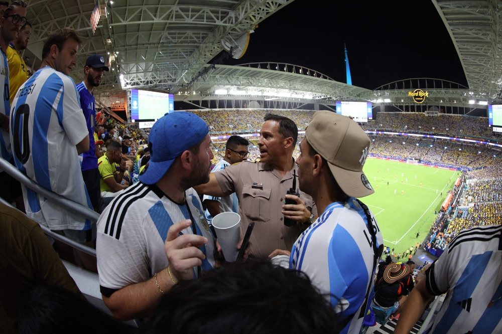 A police officer talks to fans during the Copa America 2024 match between Argentina and Colombia at theHard Rock Stadium on July 14, 2024 in Miami Gardens, Florida. — AFP pic